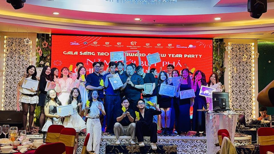 Một ảnh tập thể cuối sự kiện, mọi người đứng chung trên sân khấu, cùng hô vang hoặc giơ cao biểu tượng quyết tâm.