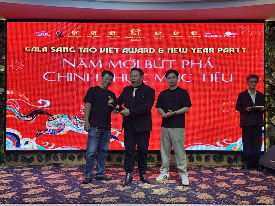 Ảnh chụp toàn cảnh sân khấu chính của đêm Gala với banner Sáng Tạo Việt Award 2025, có đầy đủ ánh sáng, màu sắc ấm cúng, có thể thấy rõ dòng chữ sự kiện và logo công ty.